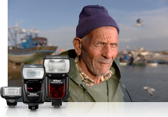 Image of three Speedlights clustered in front of a photo of an old man near the sea, with a harbor in the background