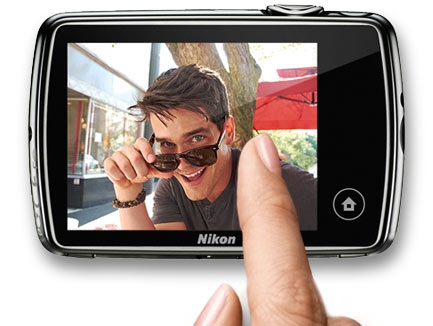 COOLPIX S01 has an intuitive touchscreen display photo of woman's finger on the touchscreen of the S01 with a photo of a young man on the LCD