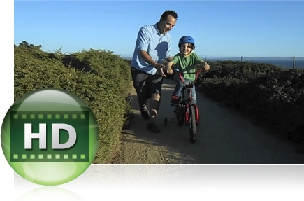 photo of a dad holding the handlebars of his son's bike as he learns to ride and HD video icon